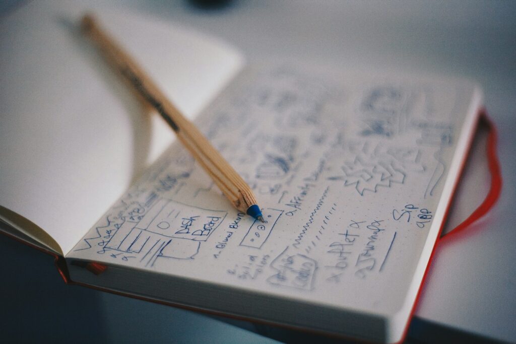Pen and notebook beside free word processing software for notes and drafts