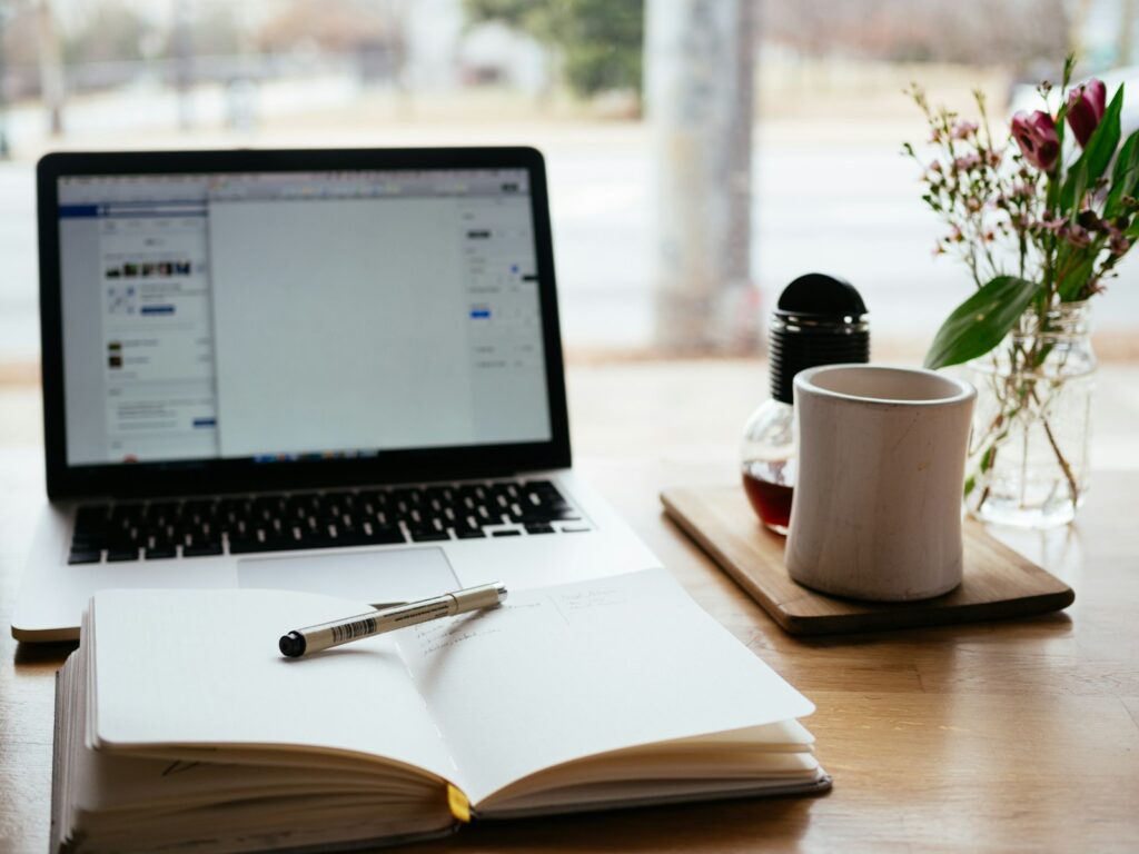 Laptop and open book used for writing documents in a free office suite