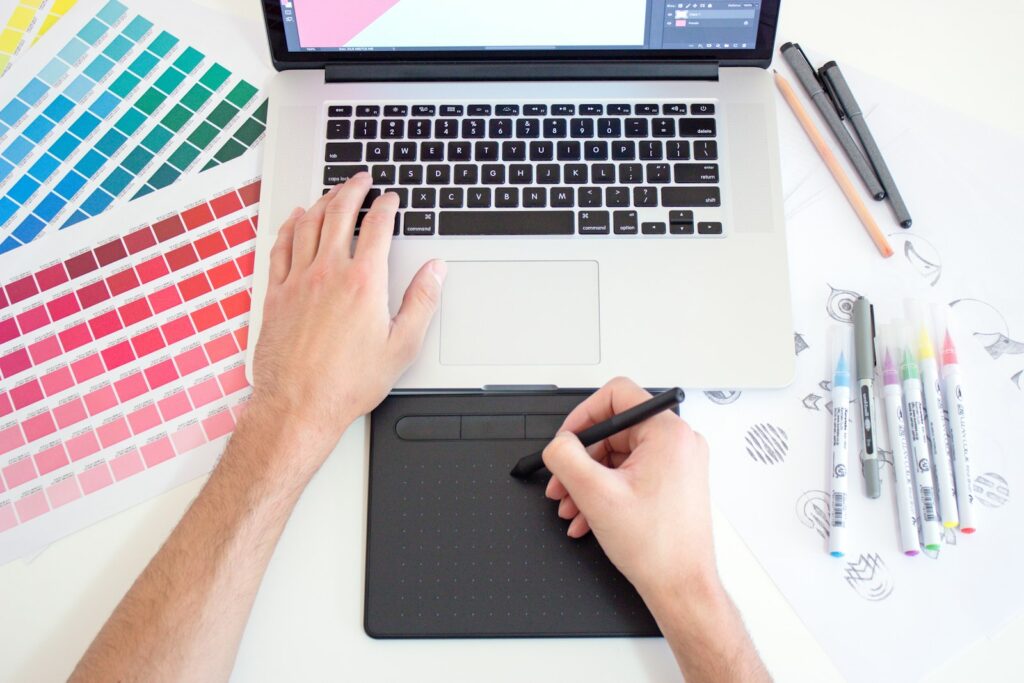 Designer editing images with a tablet and laptop using a free Photoshop alternative