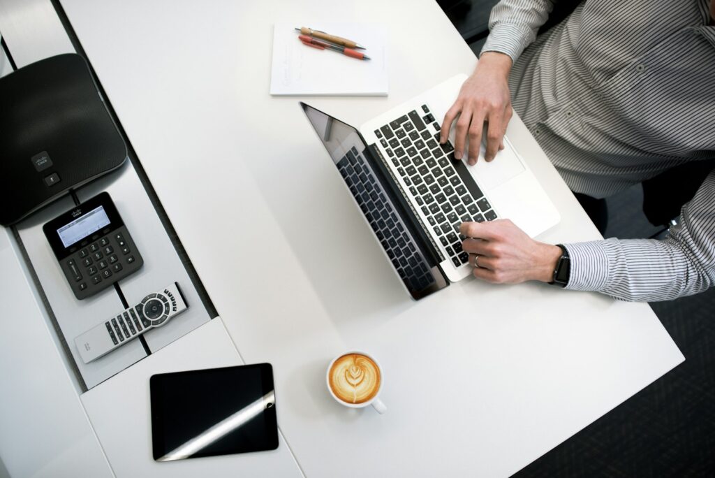 Person using a laptop to fill and sign a PDF form with a free editor