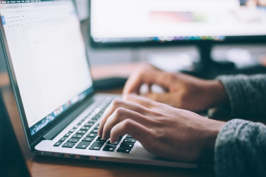 Person using a laptop to update a sales pipeline in a free CRM