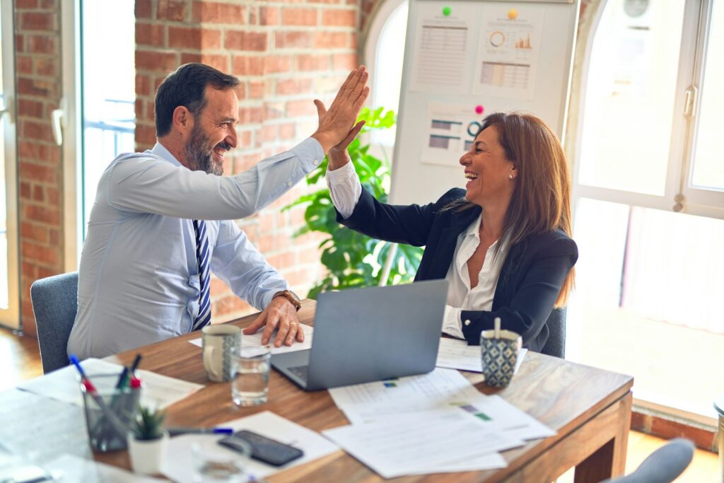 Two coworkers reviewing customer details in a small business CRM